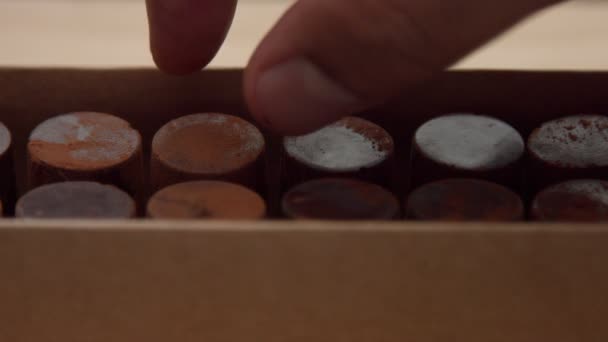 primo piano della scatola di caramelle al cioccolato e una mano di uomini ne ha raccolto uno
 - Filmati, video