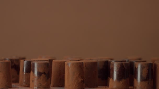 Niektóre czekolada candys na brązowym tle w studio - Materiał filmowy, wideo