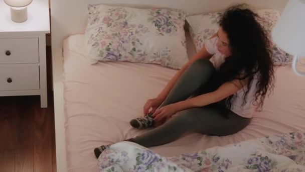 Curly Woman is putting on socks - Footage, Video