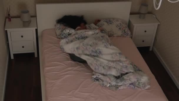 Dívka se neklidně spí na posteli v noci pohled shora - Záběry, video