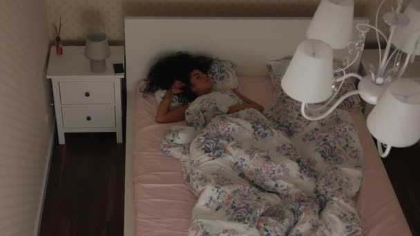 Dziewczyna, przepastnych śpi na łóżku w nocy widok z góry - Materiał filmowy, wideo