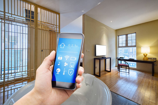 смартфон со смарт-домом и современной ванной комнатой в отеле
 - Фото, изображение