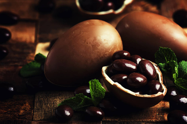 Easter composition with chocolate eggs, vintage wooden background, rustic style, selective focus - Foto, Bild