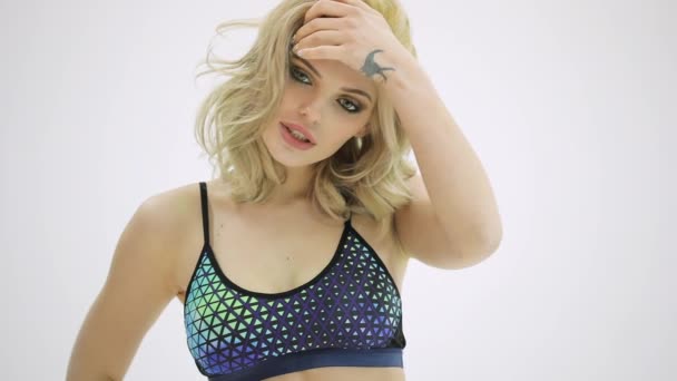 Gyönyörű vonzó modell a Sportruházat pózol egy stúdió fehér háttér - Felvétel, videó