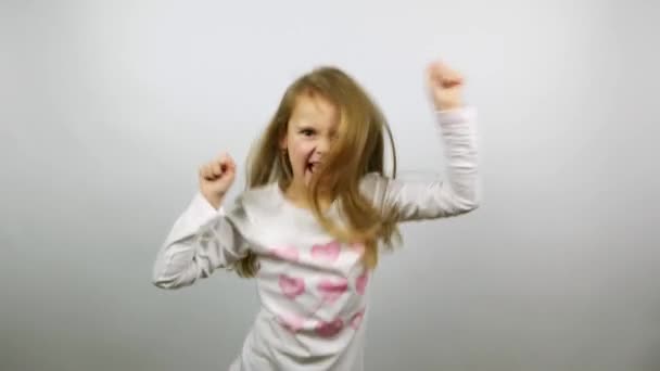 Lustiger Kindertanz. junges amüsantes Mädchen jubelt über den Sieg - Filmmaterial, Video