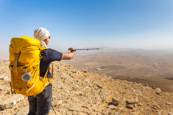 Τουριστικό οδηγό backpacker κατάδειξης δείχνει τις κατευθύνσεις της ερήμου Μουν - Φωτογραφία, εικόνα