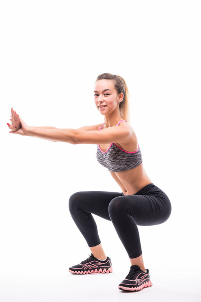 mujer fitness deporte, joven niña sana haciendo ejercicios en cuclillas, retrato de cuerpo entero sobre fondo blanco
 - Foto, Imagen