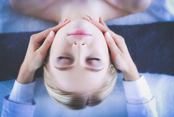 Young woman lying on a massage table,relaxing with eyes closed. Woman. Spa salon - Photo, Image