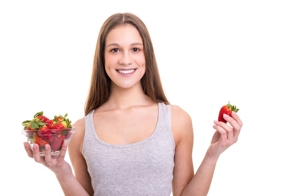 schöne junge Frau hält ein paar Erdbeeren, isoliert über weißem Hintergrund - Foto, Bild