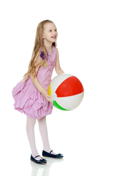 Όμορφο μικρό κορίτσι με ένα μεγάλο πολύχρωμο φουσκωτή μπάλα - Φωτογραφία, εικόνα