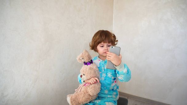 Pieni puolalainen tyttö opiskelee mahdollisuuksia älypuhelimen
. - Valokuva, kuva