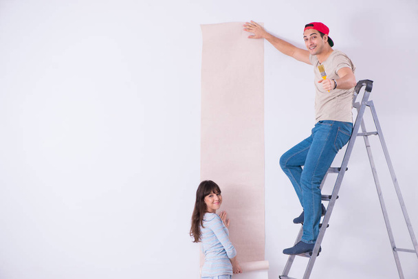Young family doing renovation at home with new wallpaper - 写真・画像