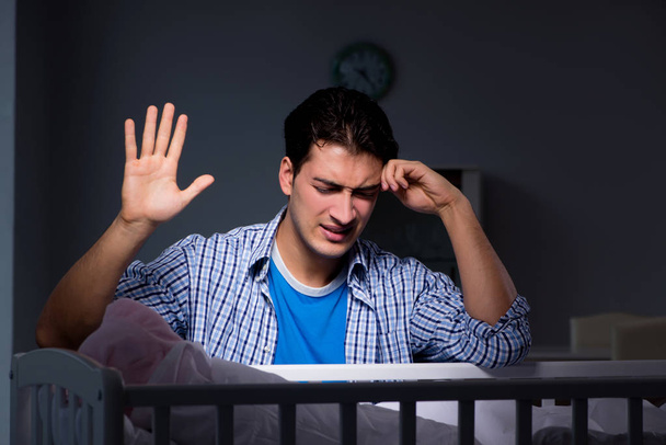 Jovem pai sob estresse devido ao bebê chorando à noite
 - Foto, Imagem