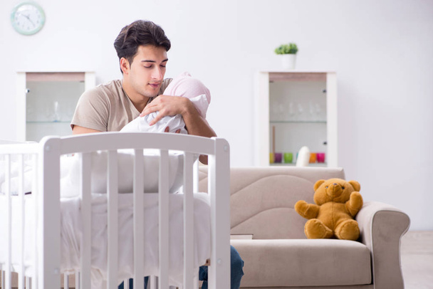 Young father enjoying time with newborn baby at home - Photo, Image