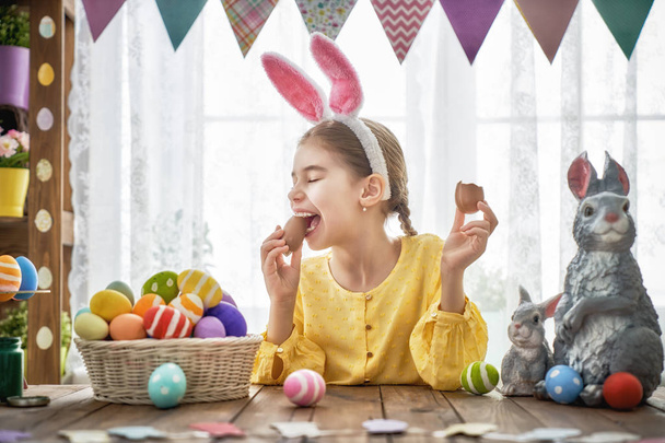 child is eating chocolate eggs - Foto, imagen