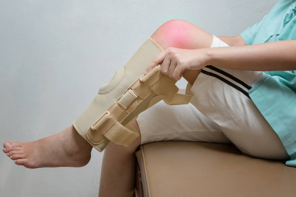 Injured woman wearing elastic knee brace in rehabilitation cente - Photo, Image