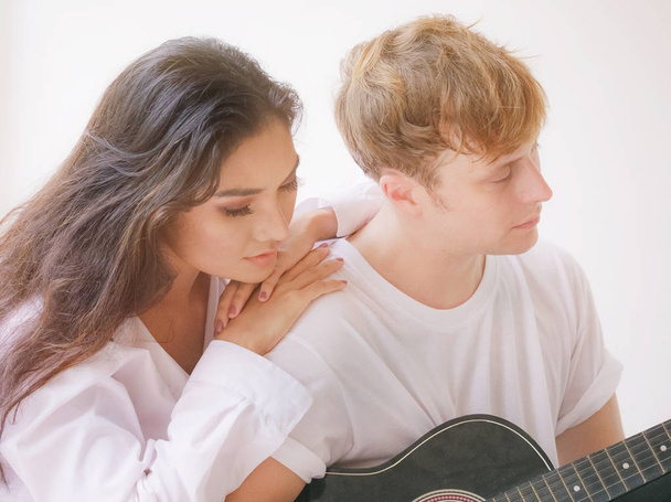 Couple in love playing acoustic guitar in the home - Zdjęcie, obraz
