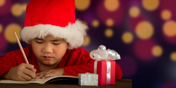 クリスマスの日の概念、子供たちに手紙を書いてサンタ クロース暗い背景のボケに対して - 写真・画像