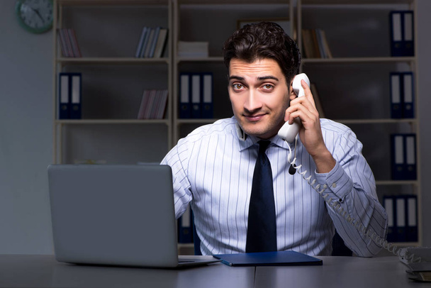 Call center operator talking to customer during night shift  - Photo, Image