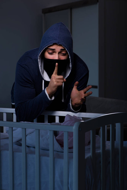 Robo criminal de bebé en concepto de tráfico de niños humanos - Foto, imagen