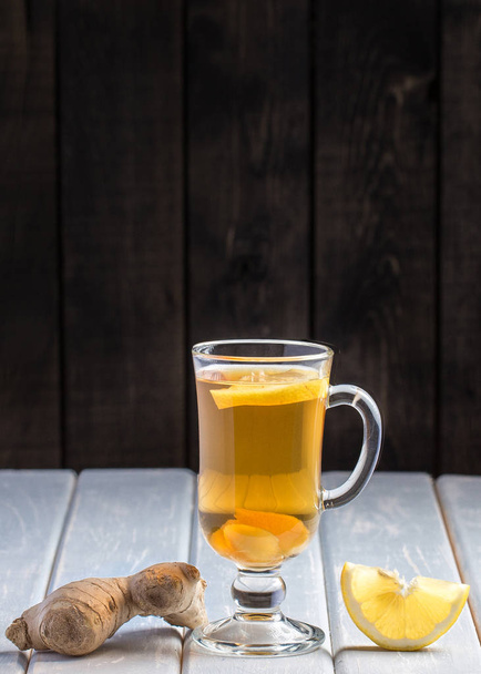 Una taza de té de jengibre con limón sobre un fondo de madera
 - Foto, imagen