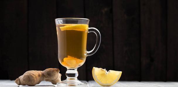 A cup of ginger tea with lemon on a wooden background - Zdjęcie, obraz