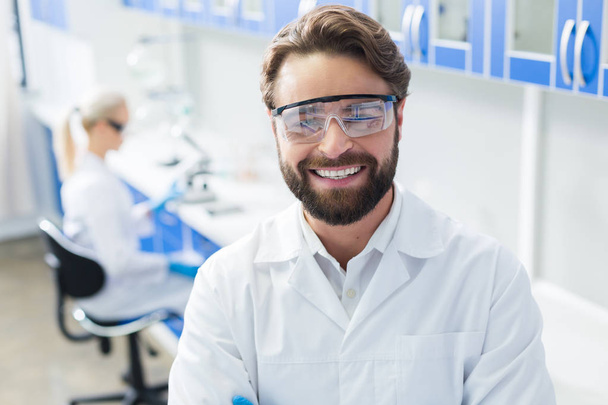 Happy bearded scientist wearing protective equipment - Foto, afbeelding