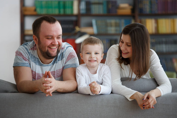 Imagen de padres con niños en sofá gris
 - Foto, Imagen