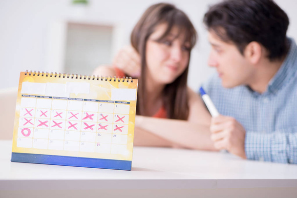 Jong gezin in zwangerschap planning concept met ovulatie kalend - Foto, afbeelding