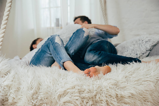 Mladý pár v džínách na věšák postel - Fotografie, Obrázek