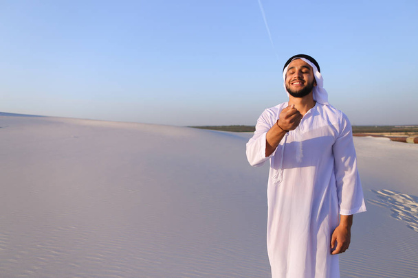 Porträt eines muslimischen Mannes in der Sandwüste an einem klaren Sommernachmittag - Foto, Bild