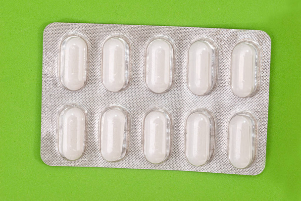 Pilules en plaquettes thermoformées isolées sur vert
 - Photo, image
