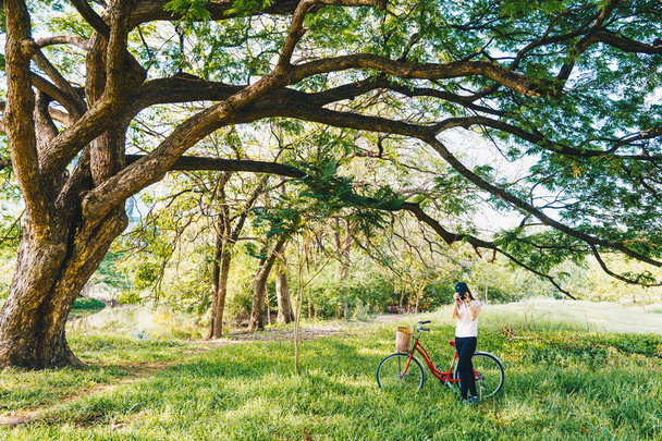 Csípő nők zöld parkban a kerékpár fog fénykép - Fotó, kép