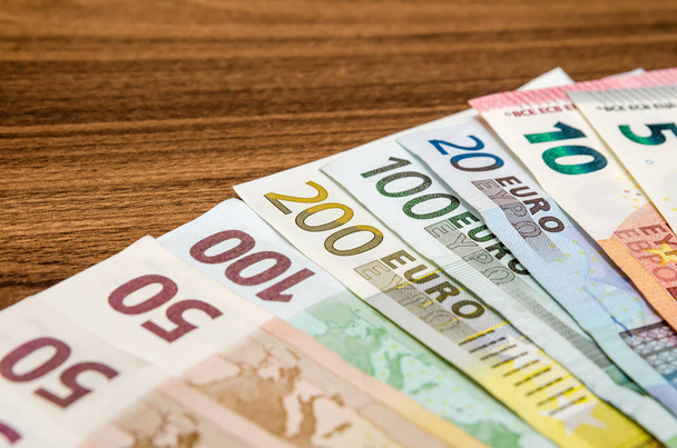 various euro notes on wooden table - Fotografie, Obrázek