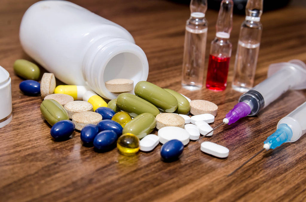 Tabletten, Injektionen und Fläschchen auf dem Tisch - Foto, Bild