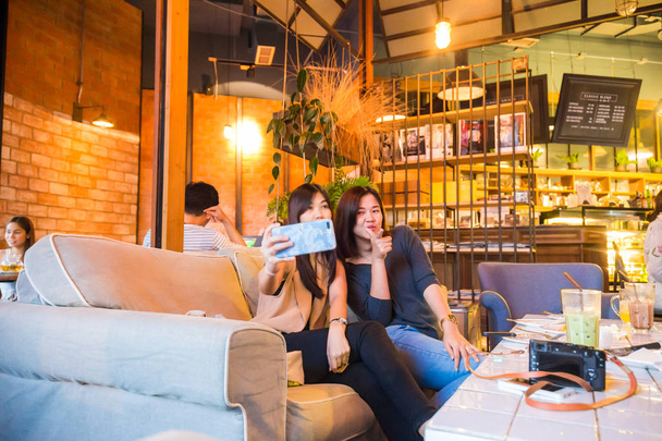 Όμορφη ασιατικές γυναίκες Πάρτε selfie φωτογραφία με τον φίλο στο Cafe, έννοια της μόδας - Φωτογραφία, εικόνα