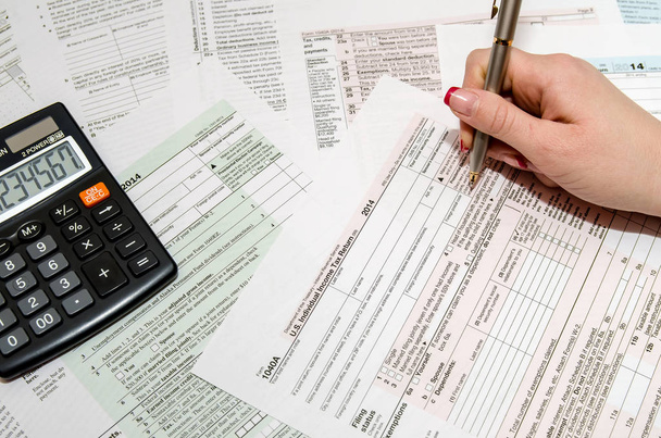 Mujer cumplimentando Formulario de Impuestos US 1040
 - Foto, Imagen