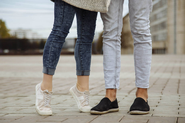 Closeup of feet of young people kissing and walking in the city - Foto, afbeelding