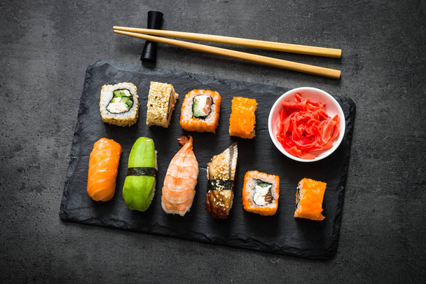 Sushi és sushi roll készlet a fekete kő asztal felülnézet - Fotó, kép