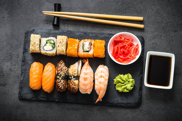 Ensemble de sushis et rouleaux de sushi sur table en pierre noire vue du dessus
 - Photo, image