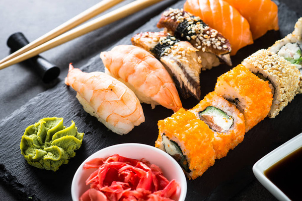 Sushi and sushi roll set on black stone table. - Photo, Image