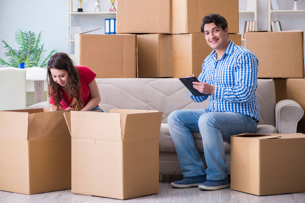 Молодая пара переезжает в новый дом с коробками - Фото, изображение