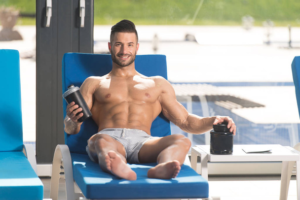Man Resting on Lounger With Supplements and Shaker - Photo, Image