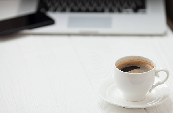 Coffee Cup on the wooden table on blurred laptop background for Business Concept. - Foto, Imagen