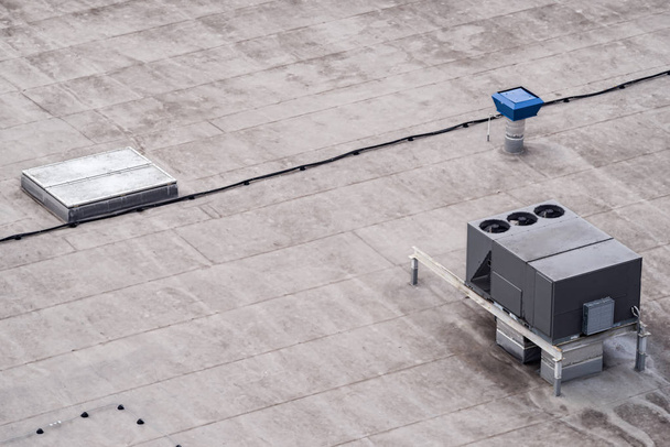 De externe eenheden van de commerciële airconditioning- en ventilatiesystemen zijn geïnstalleerd op het dak van een industrieel gebouw.. - Foto, afbeelding
