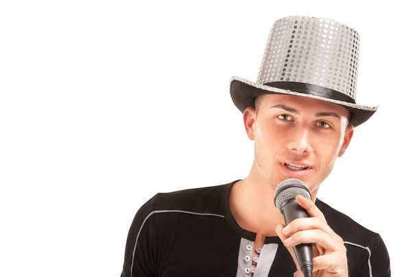 Man in the hat sings expressively into microphone. - 写真・画像