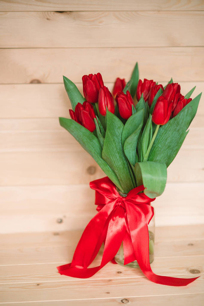 Red tulips on a wooden background - Fotó, kép