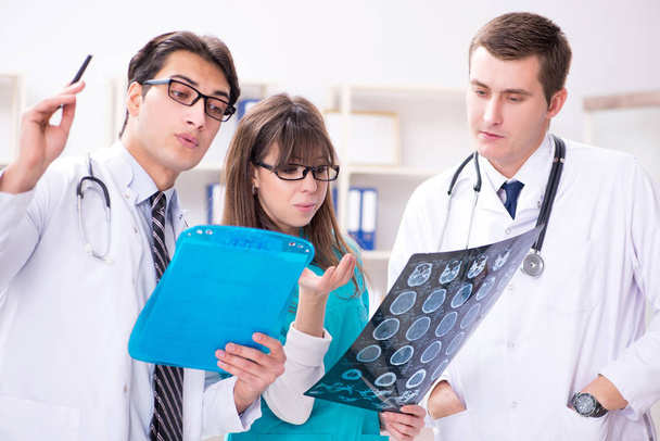 Three doctors discussing scan results of x-ray image - Photo, Image