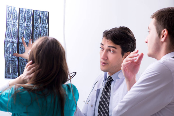 Kolme lääkäriä keskustelee röntgenkuvan tuloksista - Valokuva, kuva