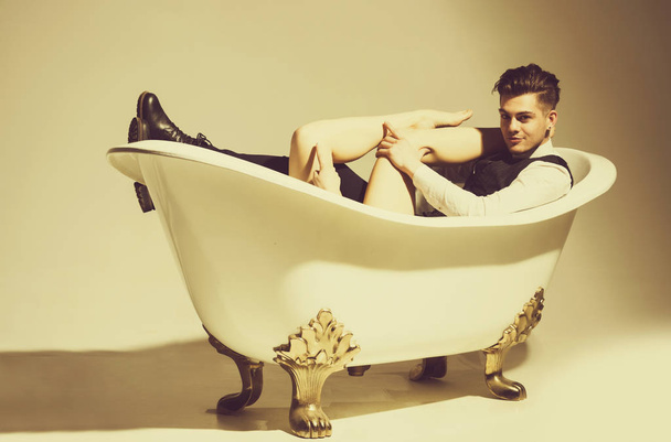 Bonito homem relaxante com sexy nu pernas femininas no banho
 - Foto, Imagem